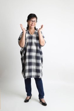 Beyaz arka planda duran yaşlı Asyalı kadın..