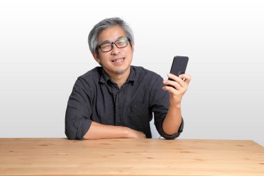 Masada oturan kıdemli Asyalı adam..