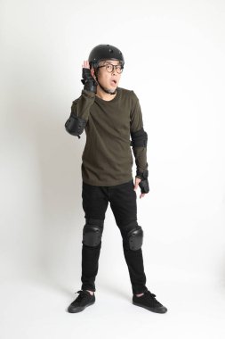 Beyaz arka planda duran koruyucu donanımlı Asyalı adam..