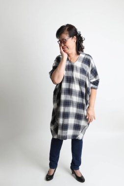 Beyaz arka planda duran yaşlı Asyalı kadın..