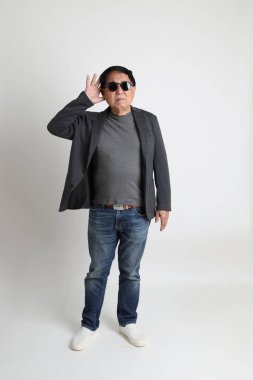 Beyaz arka planda güneş gözlüklü Asyalı son sınıf öğrencisi..