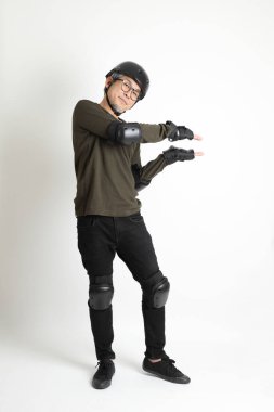 Beyaz arka planda duran koruyucu donanımlı Asyalı adam..