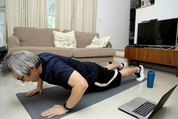 那个在客厅里锻炼的亚洲人 — 图库照片