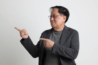 Beyaz arka planda oturan kıdemli Asyalı adam.