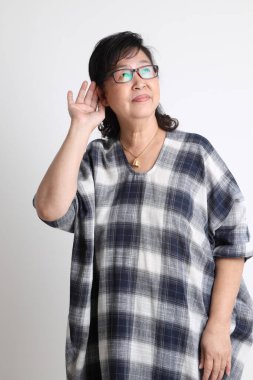 Beyaz arka planda duran yaşlı Asyalı kadın..