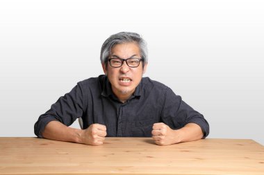 Masada oturan kıdemli Asyalı adam..