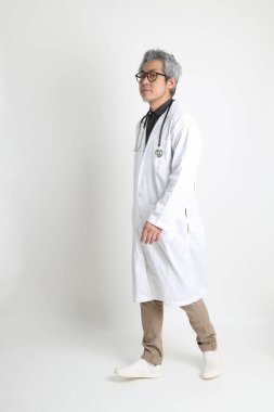 Beyaz arka plandaki kıdemli Asyalı doktor..