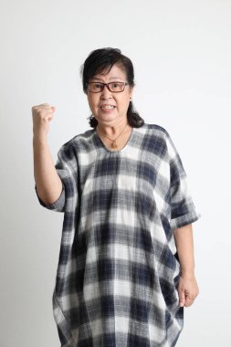 Beyaz arka planda duran yaşlı Asyalı kadın..