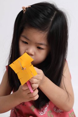 Kağıdı kesmek için makas kullanan Asyalı kız..