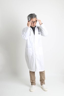 Beyaz arka plandaki kıdemli Asyalı doktor..