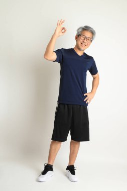 Beyaz arka planda spor giysileri olan Asyalı son sınıf öğrencisi..