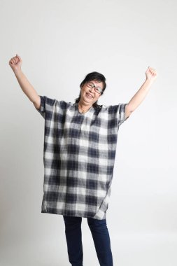 Beyaz arka planda duran yaşlı Asyalı kadın..