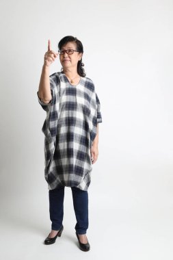 Beyaz arka planda duran yaşlı Asyalı kadın..