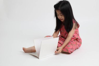 Beyaz arka planda kitap okuyan Asyalı kız..