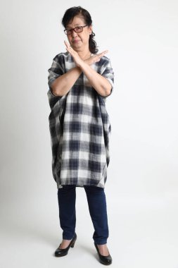 Beyaz arka planda duran yaşlı Asyalı kadın..