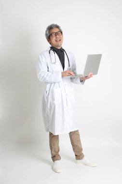 Beyaz arka plandaki kıdemli Asyalı doktor..