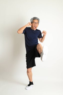 Beyaz arka planda spor giysileri olan Asyalı son sınıf öğrencisi..