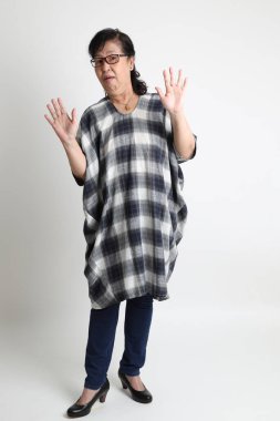 Beyaz arka planda duran yaşlı Asyalı kadın..