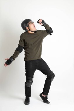 Beyaz arka planda duran koruyucu donanımlı Asyalı adam..