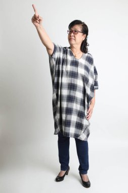 Beyaz arka planda duran yaşlı Asyalı kadın..