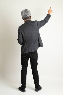 Zeki Asyalı kıdemli adam beyaz arka planda duruyor..