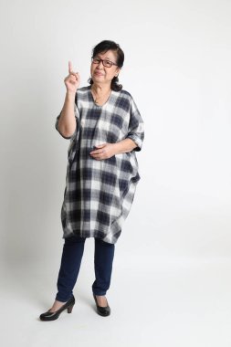 Beyaz arka planda duran yaşlı Asyalı kadın..