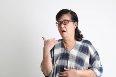 Beyaz arka planda duran yaşlı Asyalı kadın..