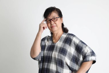 Beyaz arka planda duran yaşlı Asyalı kadın..