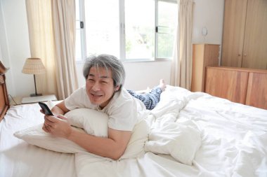 Yatak odasındaki kıdemli Asyalı adam..