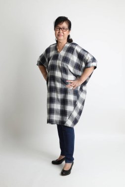 Beyaz arka planda duran yaşlı Asyalı kadın..