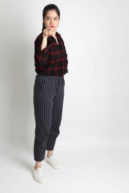 Beyaz arka planda günlük kıyafetleri olan genç Asyalı kadın..