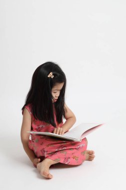 Beyaz arka planda kitap okuyan Asyalı kız..