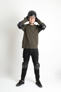 Beyaz arka planda duran koruyucu donanımlı Asyalı adam..