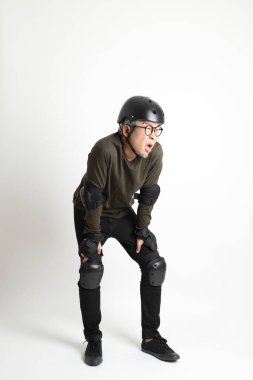 Beyaz arka planda duran koruyucu donanımlı Asyalı adam..