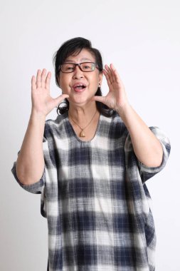 Beyaz arka planda duran yaşlı Asyalı kadın..