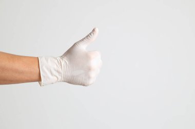 Beyaz arka planda eldivenli insan eli.