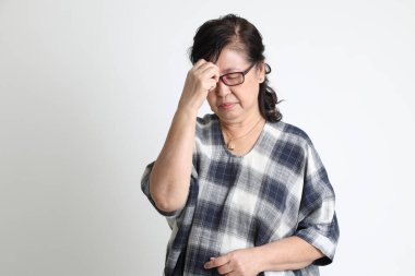 Beyaz arka planda duran yaşlı Asyalı kadın..