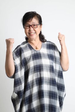 Beyaz arka planda duran yaşlı Asyalı kadın..