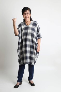 Beyaz arka planda duran yaşlı Asyalı kadın..