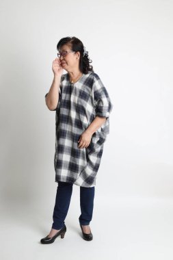 Beyaz arka planda duran yaşlı Asyalı kadın..