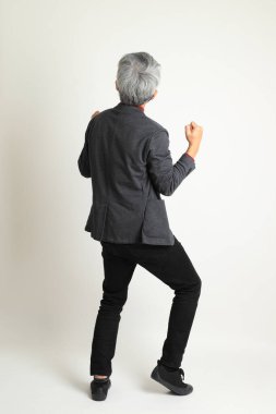 Zeki Asyalı kıdemli adam beyaz arka planda duruyor..