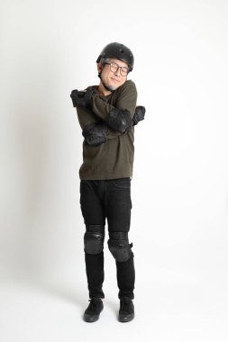 Beyaz arka planda duran koruyucu donanımlı Asyalı adam..