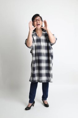 Beyaz arka planda duran yaşlı Asyalı kadın..