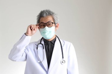Beyaz arka planda maskesi olan kıdemli Asyalı doktor..