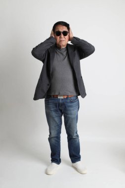 Beyaz arka planda güneş gözlüklü Asyalı son sınıf öğrencisi..