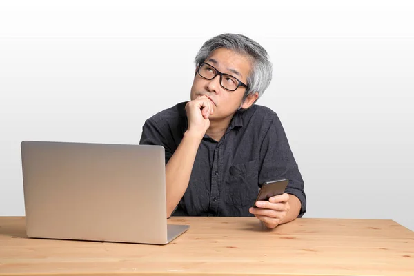 Senior Aziatische Man Zit Aan Het Bureau — Stockfoto