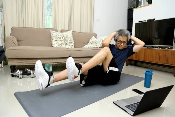 那个在客厅里锻炼的亚洲人 — 图库照片