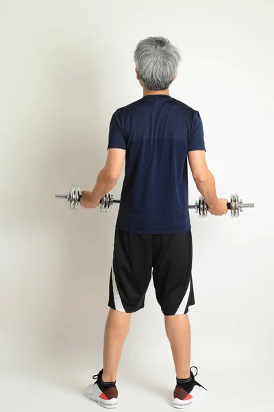 The Asian senior man with sport clothes on the white background.