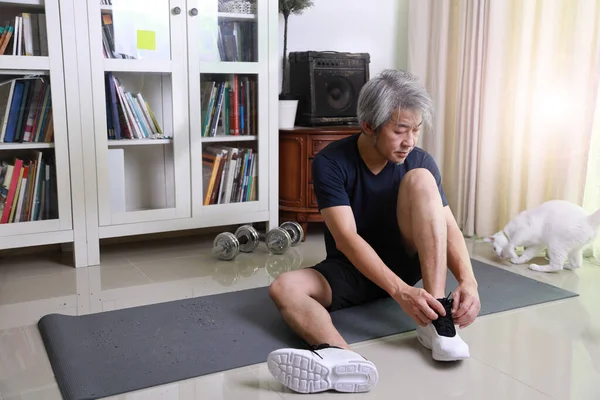 那个在客厅里做运动的亚洲老人 — 图库照片