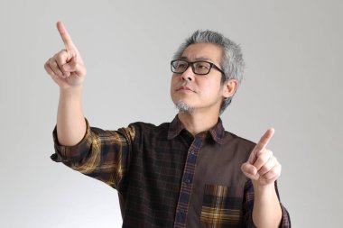 Beyaz arka planda duran kıdemli Asyalı adam.